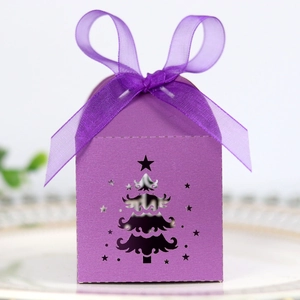 Detailed laser-cut Christmas tree pattern on purple paper gift box with silk ribbon