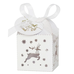 Detail of white laser-cut Christmas reindeer candy box with ribbon and thank you tag