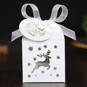 Close-up of white hollow reindeer candy box with ribbon and golden thank you tag