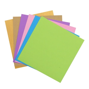 Macro view of square origami paper in glitter gold, kraft, and various pastel colors
