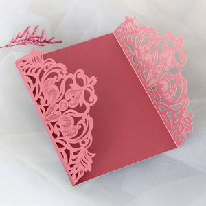 Détail de dentelle florale découpée au laser sur faire-part de mariage bordeaux chic