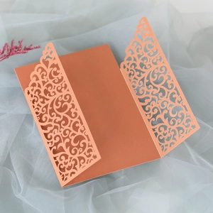Detail of rose gold laser-cut invitation holder with intricate filigree patterns