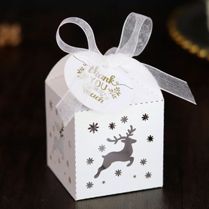 Detailed laser-cut reindeer design on white candy box with ribbon and thank you tag