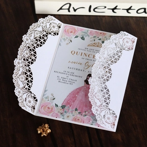 Dettaglio dell'invito tagliato al laser per Quinceañera con rose rosa e pizzo su legno scuro
