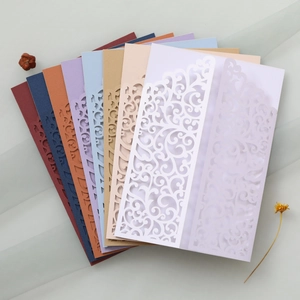 Macro detail of laser-cut European floral patterns on various colored wedding invitations