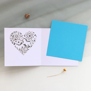 Intricate laser-cut heart pattern on hollow greeting card with butterflies and lace