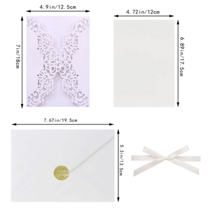 Detail of white laser-cut floral wedding invitation with golden seal and envelopes