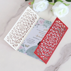 Detail of laser-cut wedding invitation with Double Happiness motif on marble background