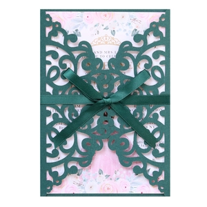 Detail of dark green laser cut wedding invitation with silk ribbon and floral insert