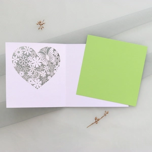 Detail of laser-cut hollow heart pattern with flowers and butterflies on white card