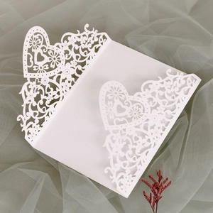 Detailed laser-cut white pearl invitation with heart and floral patterns for weddings