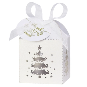 Macro shot of white laser-cut Christmas tree favor box with silk ribbon and thank you tag