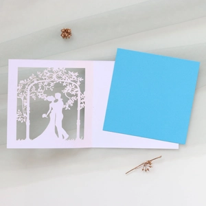 Laser-cut wedding invitation featuring a couple silhouette and blue inner card