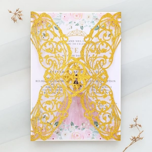 Macro view of laser-cut butterfly invitation with gold glitter texture and floral card