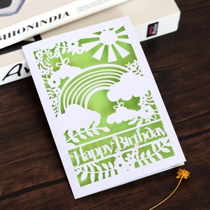 Détail de la carte d'anniversaire découpée au laser avec motifs arc-en-ciel et soleil