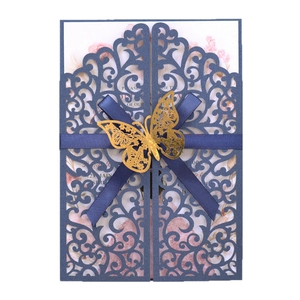 Elegant navy blue laser cut wedding invitation with blue ribbon and gold butterfly charm
