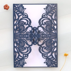 Détail de l'invitation découpée au laser bleu marine avec motifs floraux élégants