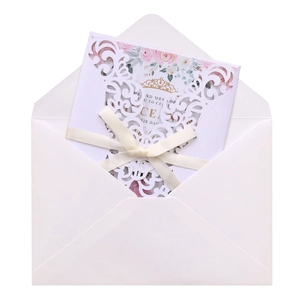 Detail of laser-cut floral wedding invitation with pink rose card and beige bow