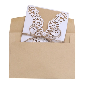 Rustic wedding invitation set with laser-cut floral card, twine bow, and kraft envelope
