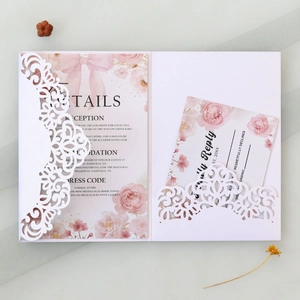 Détail d'invitation de mariage en dentelle découpée au laser avec cartes RSVP roses