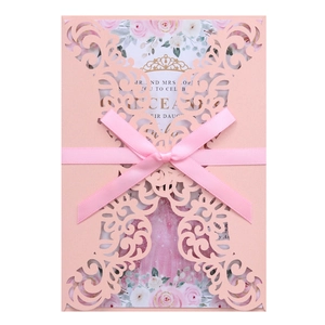 Pink laser-cut wedding invitation with elegant ribbon bow and floral inner card