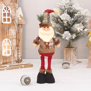 Detail of Christmas Santa plush toy with plaid hat and wooden vest in winter scene