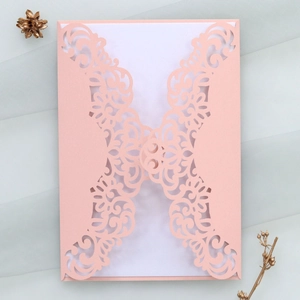 Detail of laser-cut wedding invitation cover with elegant floral patterns and mesh background