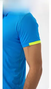Detail of sky blue polo shirt showing textured sports fabric and neon yellow cuffs