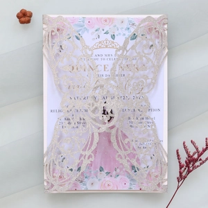 Macro shot of laser-cut silver glitter invitation featuring elegant butterfly lace patterns
