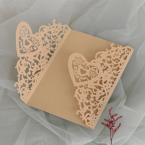 Macro shot of laser-cut heart floral patterns on elegant kraft wedding invitations