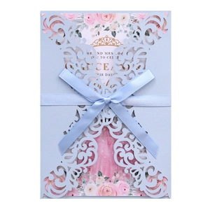 Elegant laser-cut blue wedding invitation with satin bow and golden crown floral card