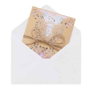 Detail of laser-cut gold glitter wedding invitation with purple floral insert and twine