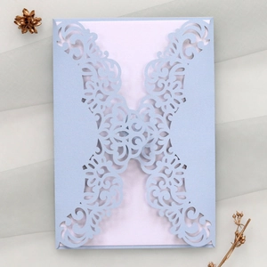 Detail of laser-cut wedding invitation featuring light blue pearlescent paper and floral pattern