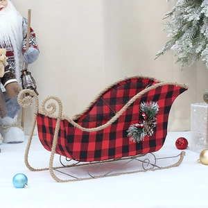 Detail of Christmas red and black plaid sleigh with pine cones and metal base