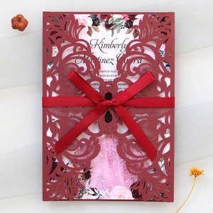 Invitation bordeaux découpée au laser avec ruban en satin rouge et page florale