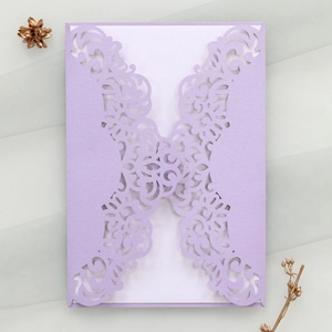 Detailed laser-cut lavender invitation card with intricate hollow pattern and white insert