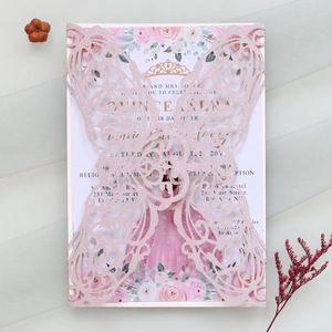 Macro detail of laser-cut butterfly invitation with pink glitter finish and floral inlay