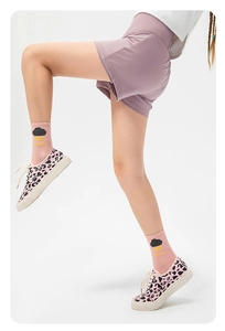 Detail view of girls purple high-waist running shorts with pink socks and leopard shoes