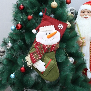 Detail of burlap Christmas stocking with 3D snowman hanging on a decorated tree