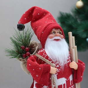 Close-up of knit Santa figurine with red reindeer patterns and burlap gift bag decoration