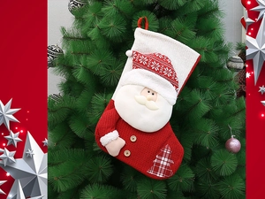 Macro detail of red and white knitted Christmas stocking featuring 3D Santa Claus figure