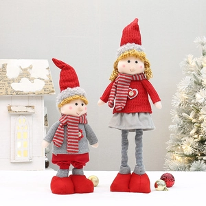 Detail view of handmade telescopic Christmas plush dolls with red hats and striped scarves