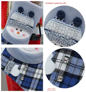 Detailed macro view of knitted cuff and metallic bell on the blue plaid Christmas stocking