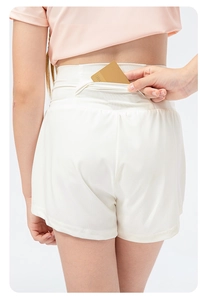 Detail showing the hidden waistband pocket on white quick-dry sports shorts for girls