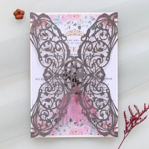 Close-up of laser-cut butterfly invitation with silver glitter texture and floral card