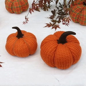 Gros plan de citrouilles décoratives en tricot et tissu à carreaux avec des feuilles