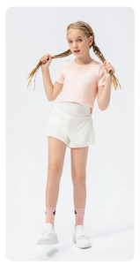 Detail view of girls' light pink crop top and white high-waisted loose sports shorts set