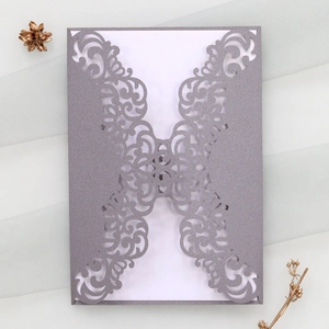 Macro detail of laser-cut glitter paper wedding invitation with elegant floral pattern