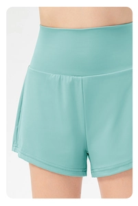 Detail shot of mint green running shorts showing high-waist elastic band and stitching