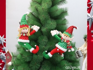 Pair of festive Christmas elf dolls with sequined hats hanging on a Christmas tree